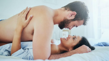 Pareja acostada en la cama sonriendo